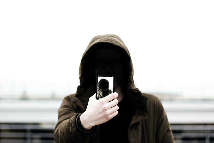 man wearing jacket using phone